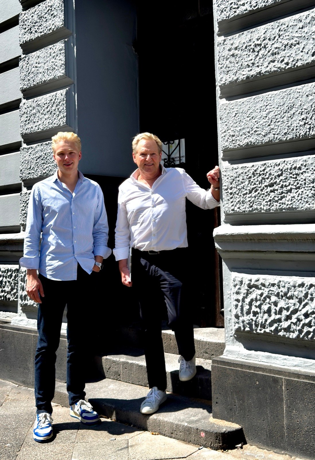 Michael und Glenn Steudel am Eingang eines Düsseldorfer Mehrfamilienhauses